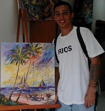 Leo Vasquez with one of his paintings in an art gallery in San Pedro, Ambergris Caye, Belize